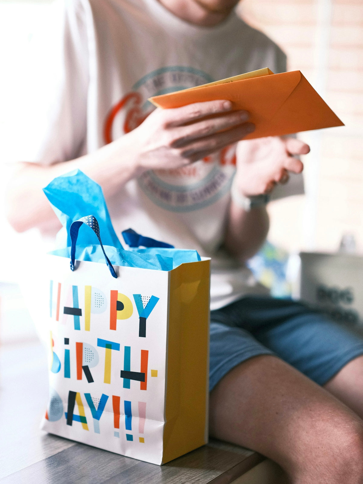 a person sitting on a table with a birthday bag