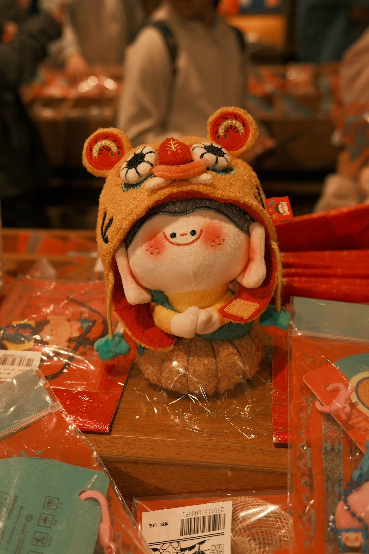 A cute plush toy wearing a tiger hat.