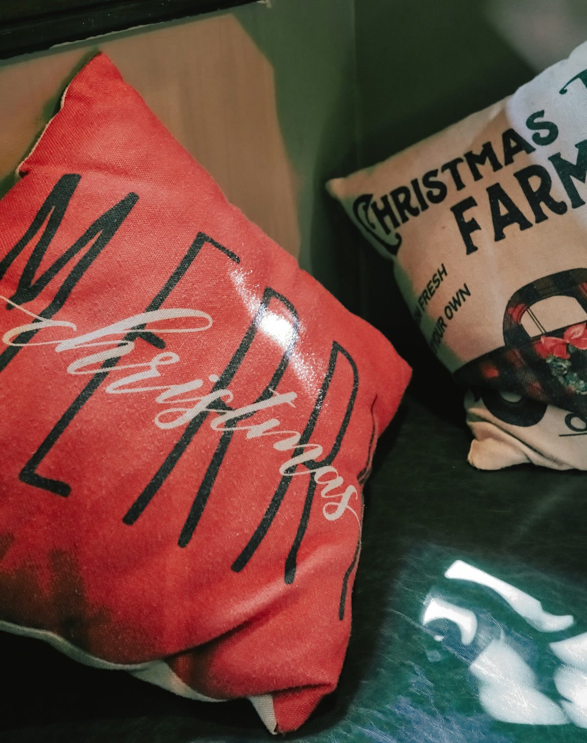 Two christmas themed pillows on a dark surface