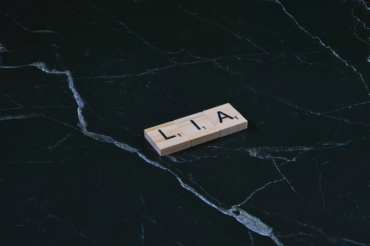 Wooden tile with lia letters on dark marble