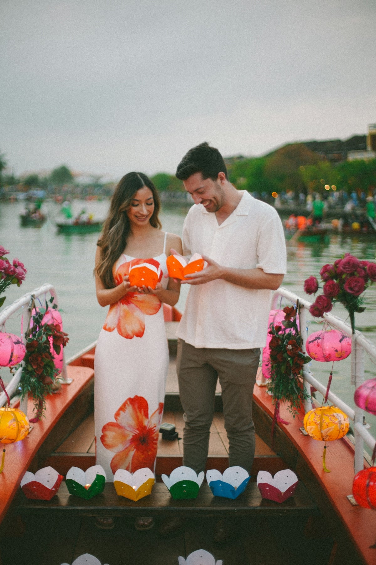 Couple on a boat holding lanterns