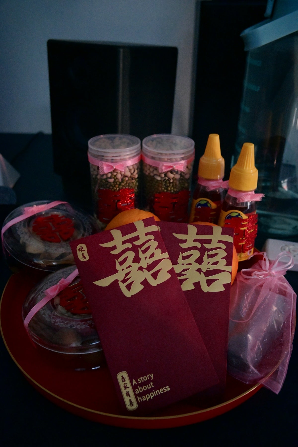 Chinese wedding gifts with red envelopes, oranges, and traditional items.